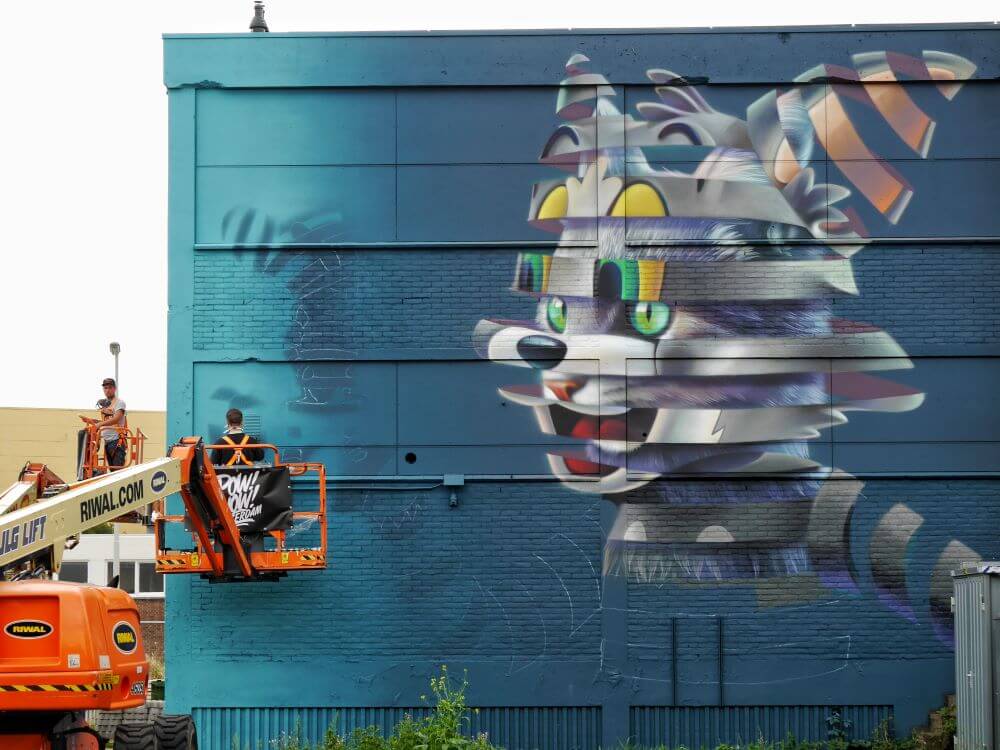 Riwal bomlift benyttes af graffitikunstner til malerarbejde ved Pow! Wow! street art festival i Rotterdam, Holland. 