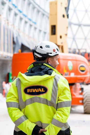 Riwal medarbejder på en byggeplads for at hjælpe kunde med lift leje